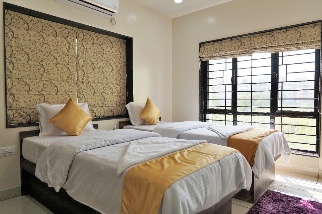Comfortable guest bedroom with twin beds at Rama Golden Roots