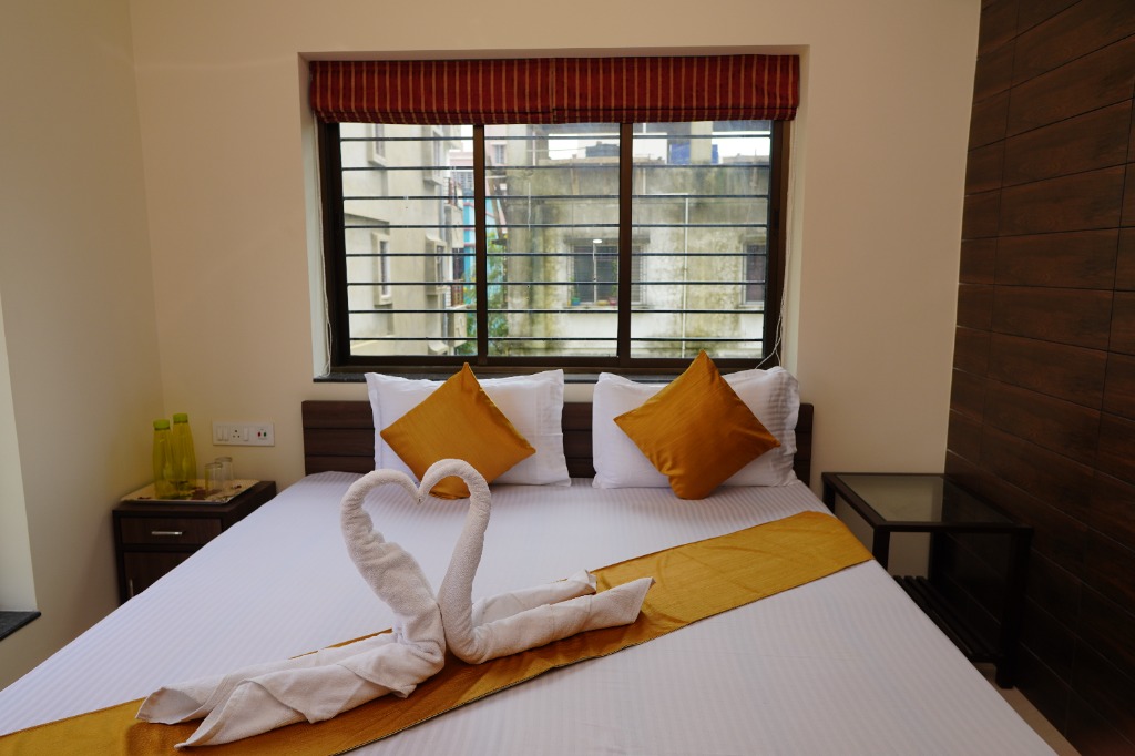 Comfortable guest bedroom with towel art and window view